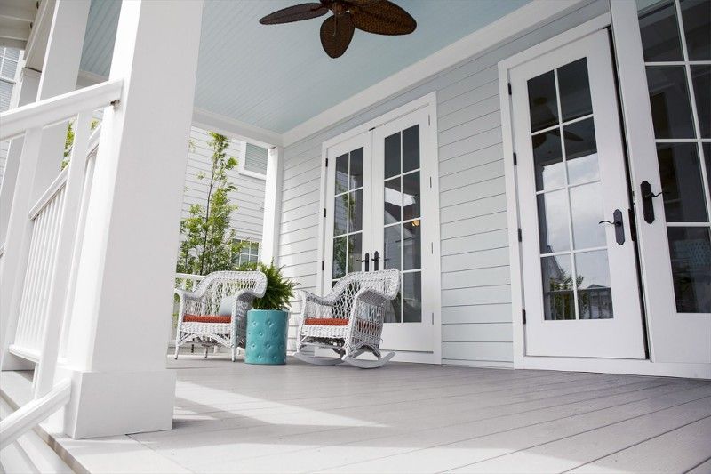 A porch with rocking chairs and a ceiling fan