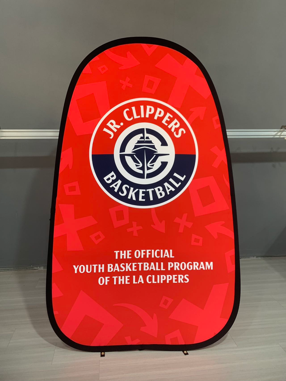 Red Jr. Clippers Basketball banner with team logo and text,