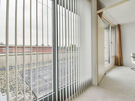 A room with a sliding glass door and vertical blinds