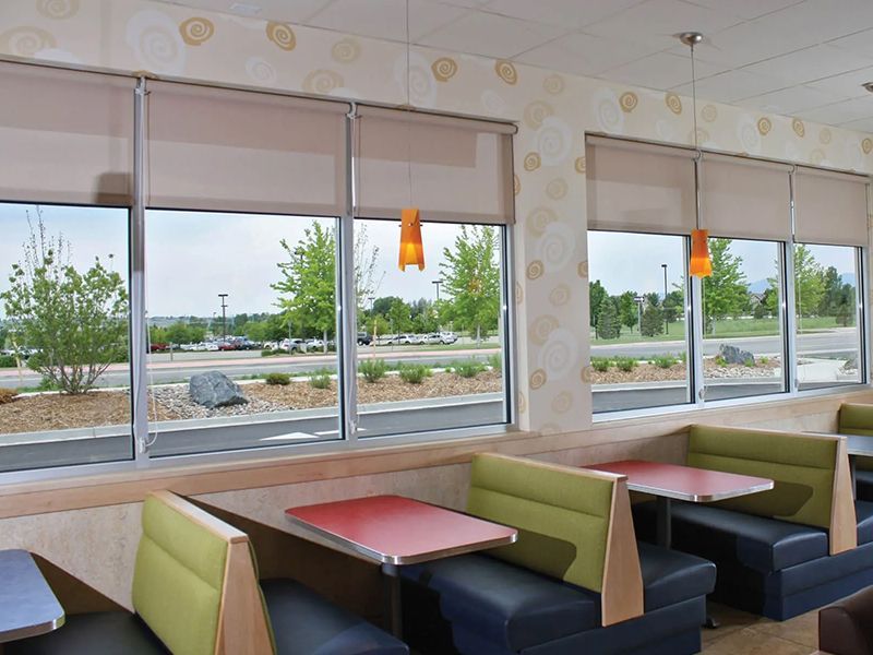 A restaurant with tables and booths and lots of windows