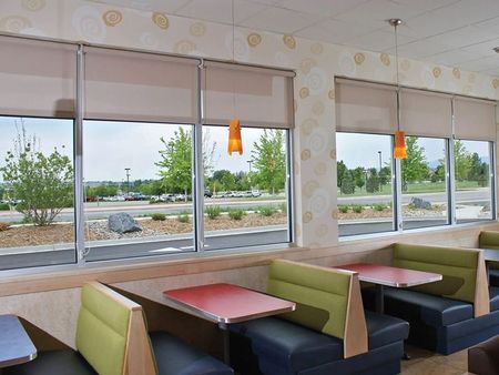 A restaurant with tables and booths and lots of windows
