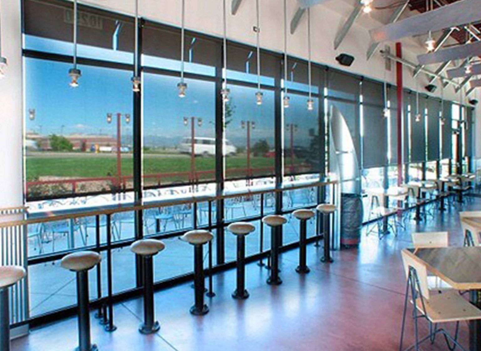 A restaurant with a lot of windows and tables and chairs