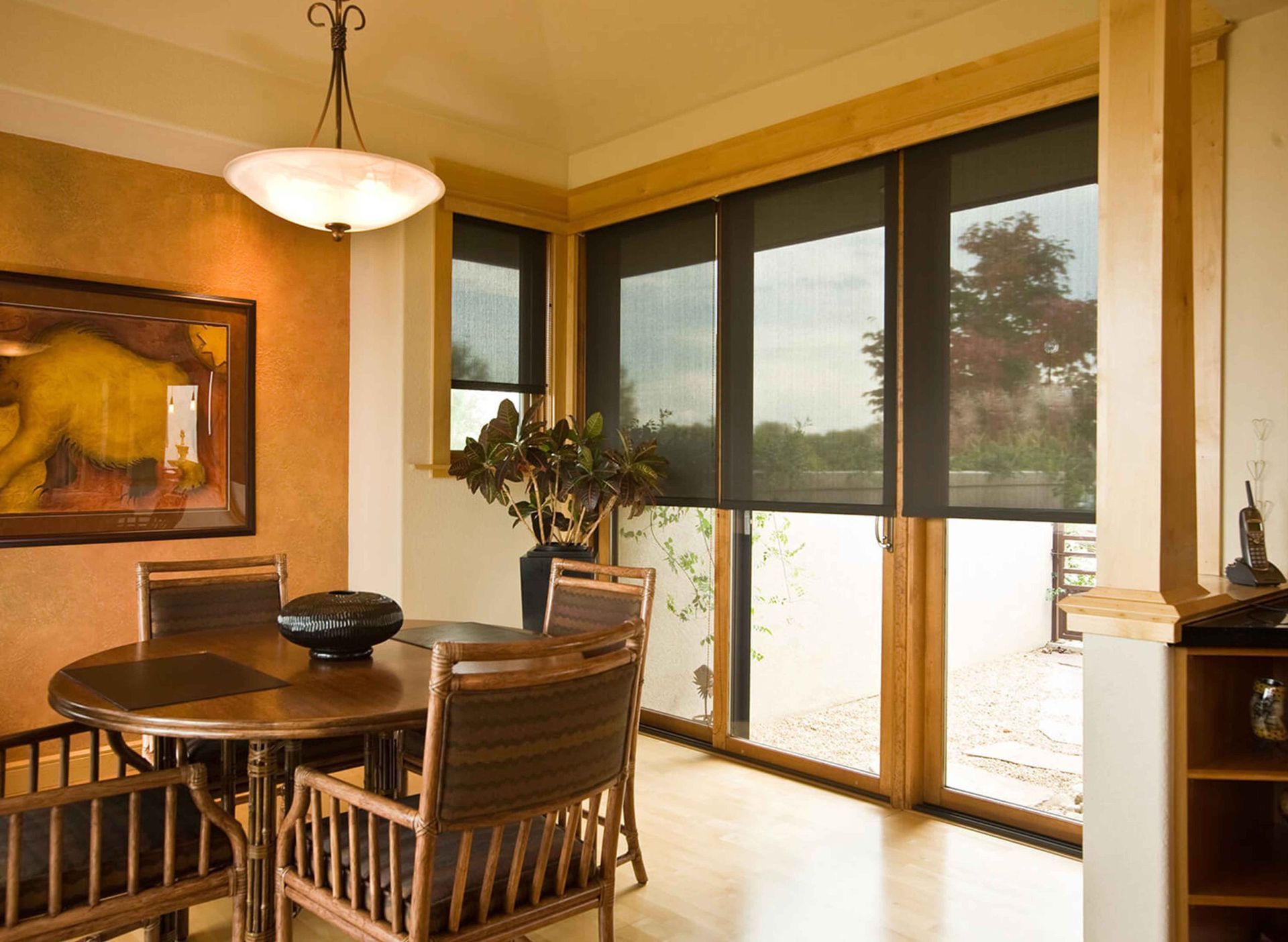 A dining room with a table and chairs and a picture on the wall
