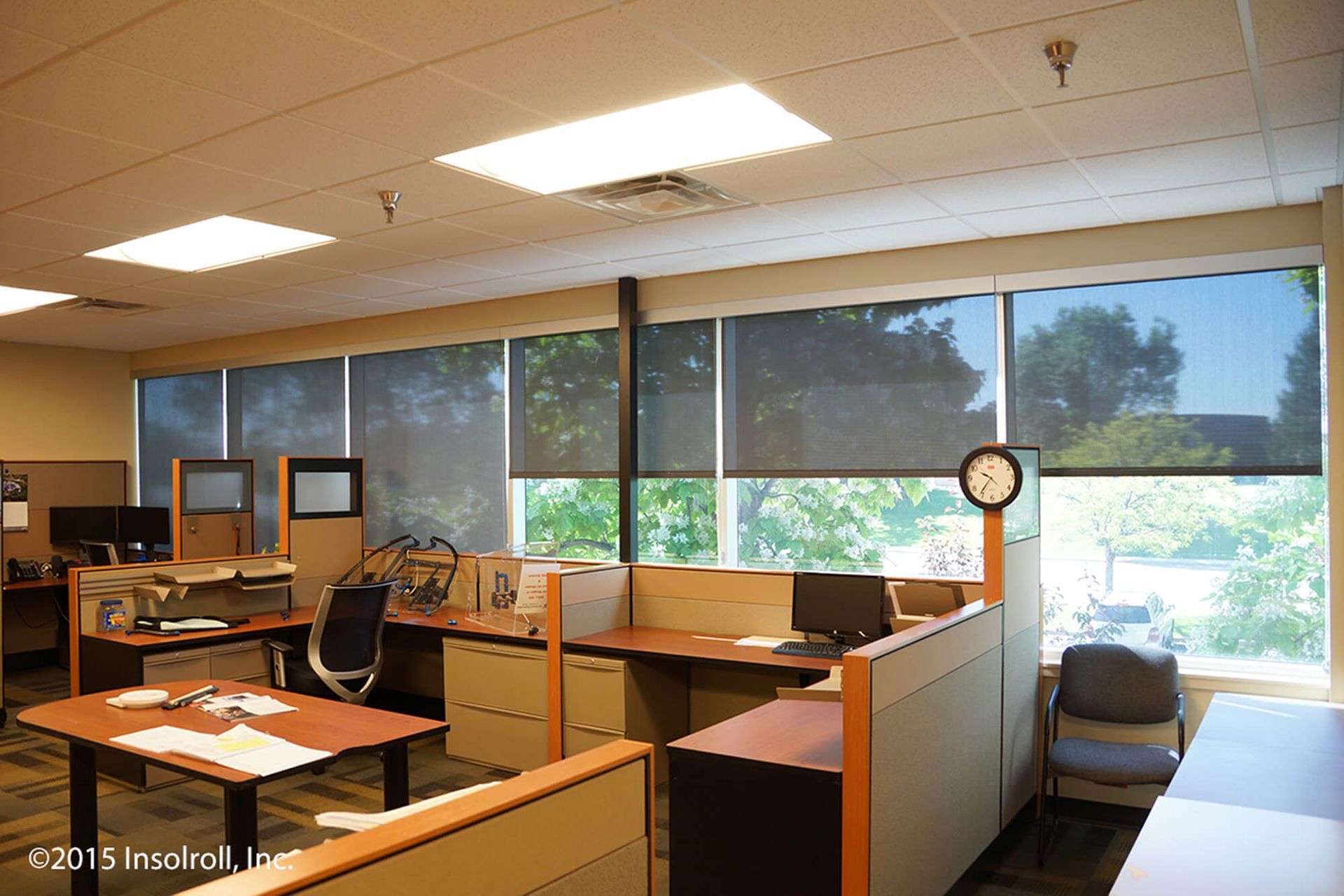 An office with cubicles and a clock on the wall