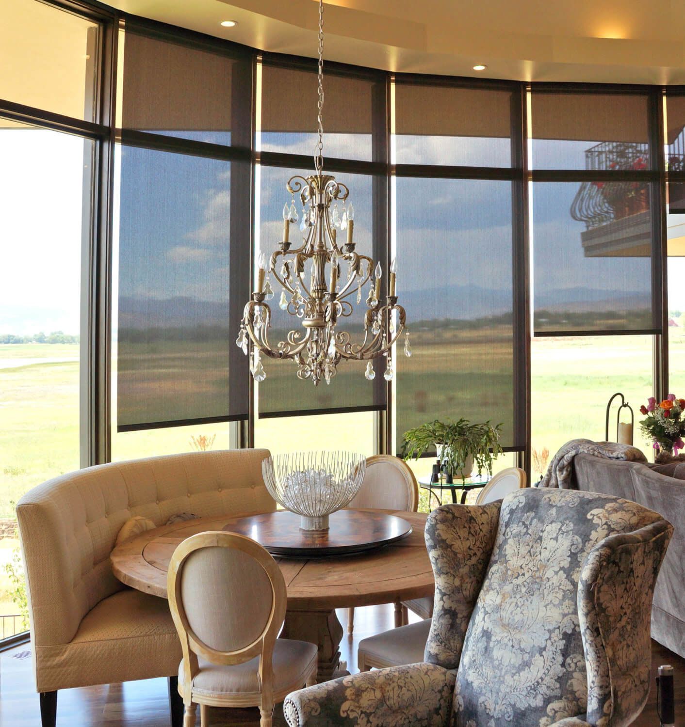 A living room with a table and chairs and a chandelier hanging from the ceiling