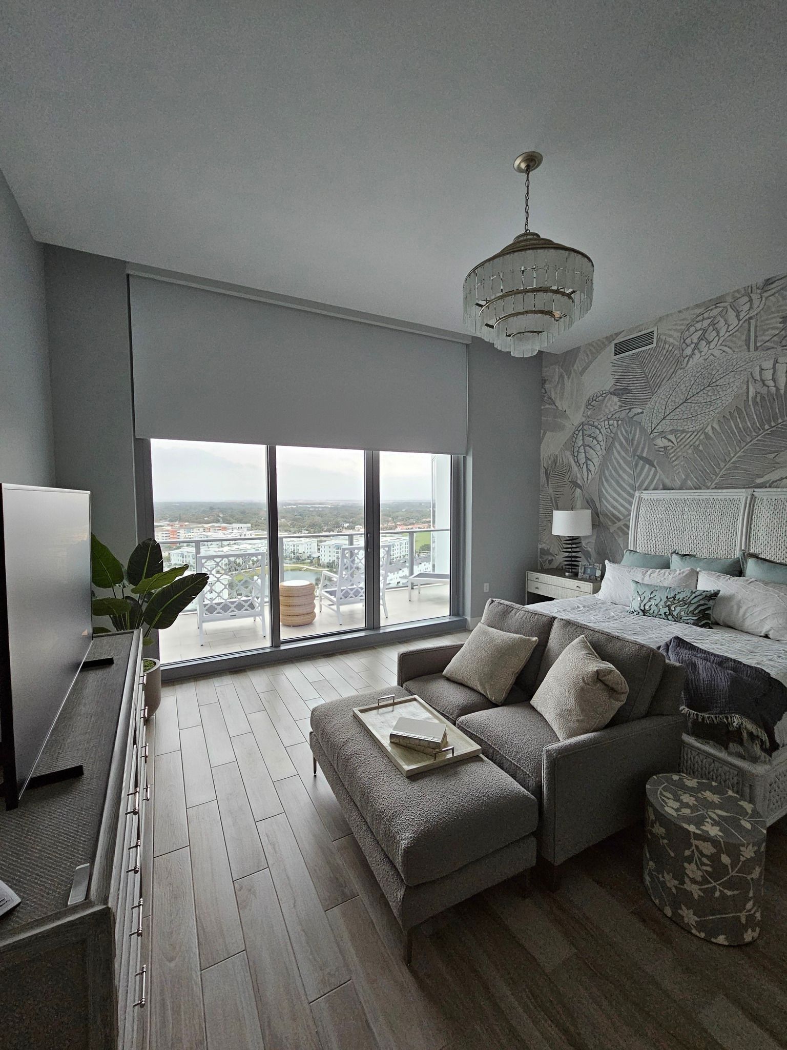 A living room with a couch , ottoman , and television.