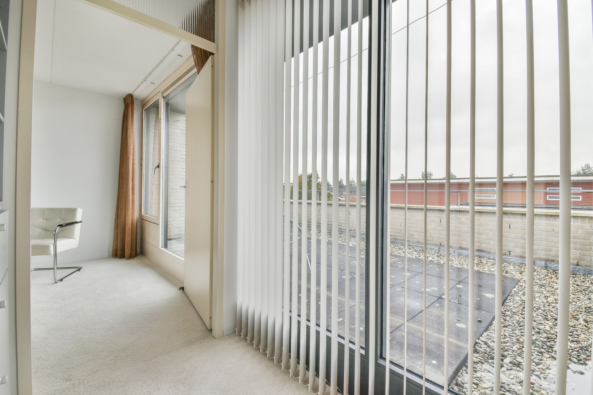 A room with a lot of windows and vertical blinds