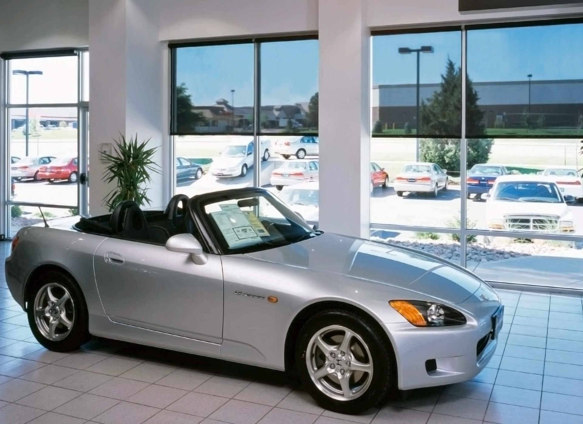 A silver sports car is parked in a showroom