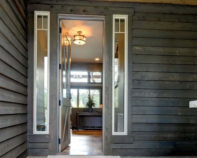The front door of a house is open to a living room