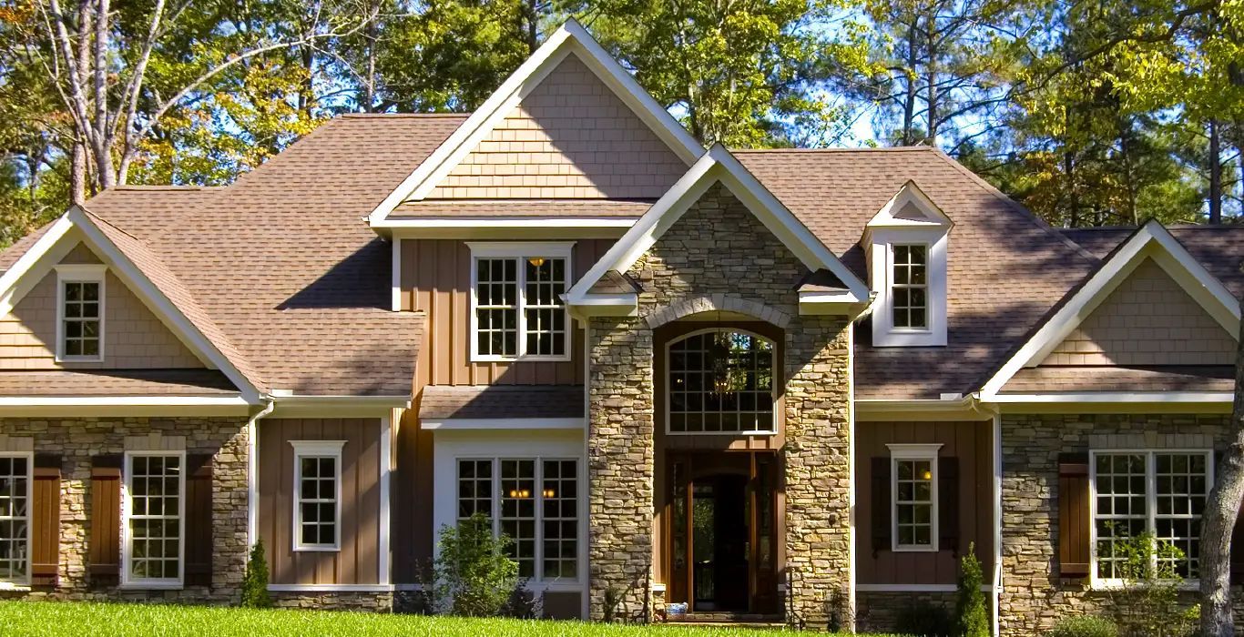 A large house with a lot of windows and trees in the background