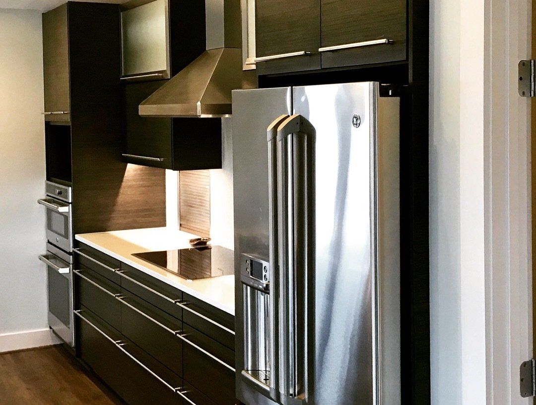 A kitchen with stainless steel appliances and black cabinets