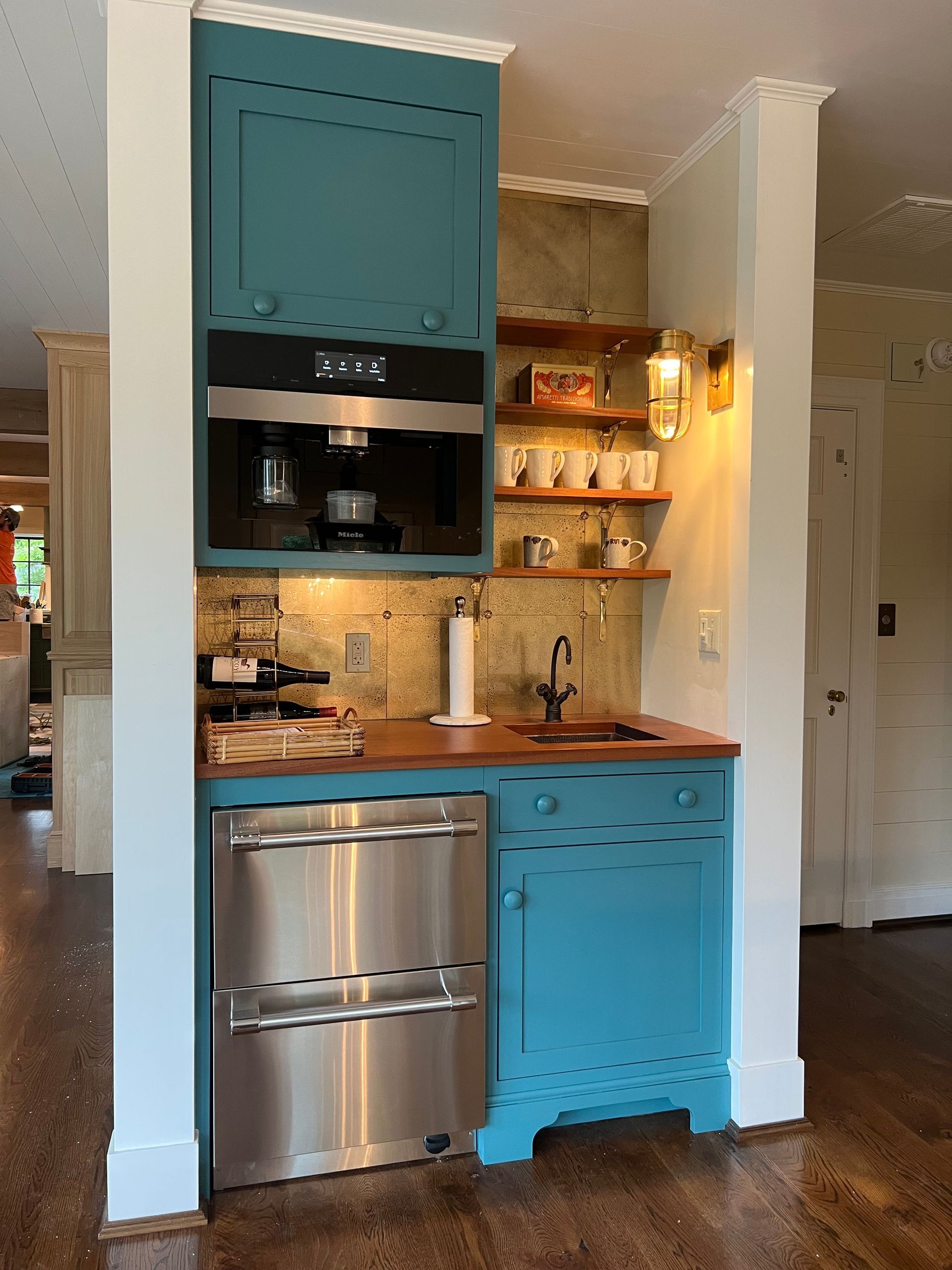 A kitchen with blue cabinets and a stainless steel dishwasher