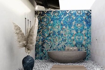 A bathroom with a bathtub and a vase of dried flowers.