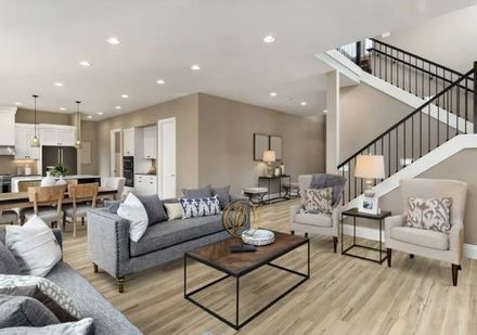 A living room with a couch and chairs and a white tile floor.