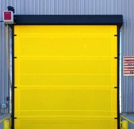 A large yellow door is sitting in front of a building.