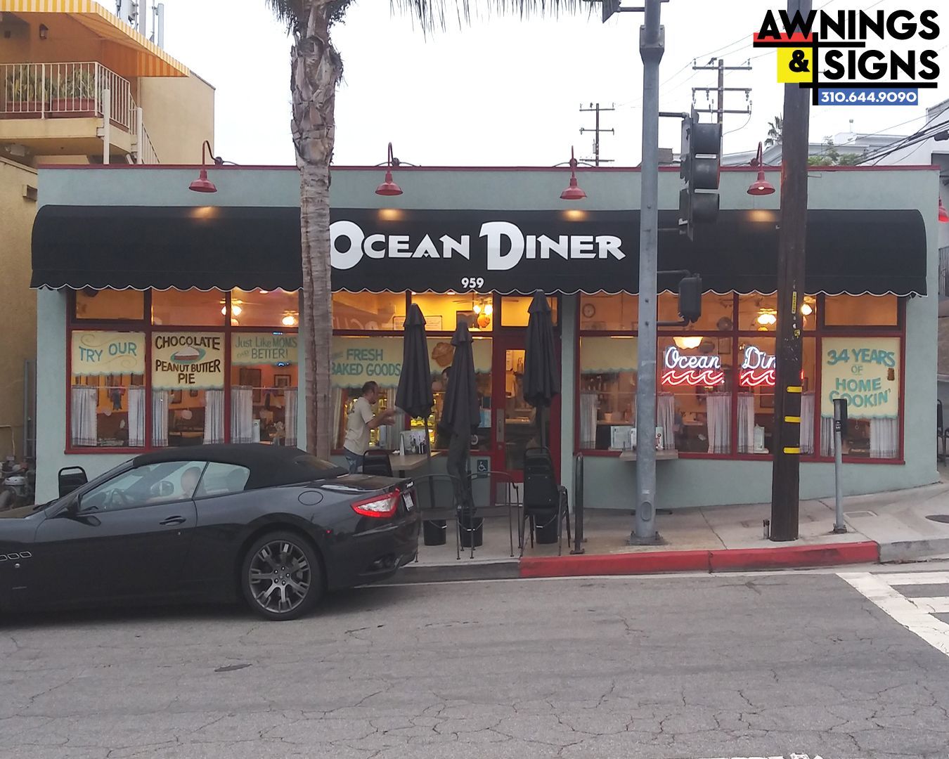 Ocean Diner with black awning, neon sign, and black car parked on the street.