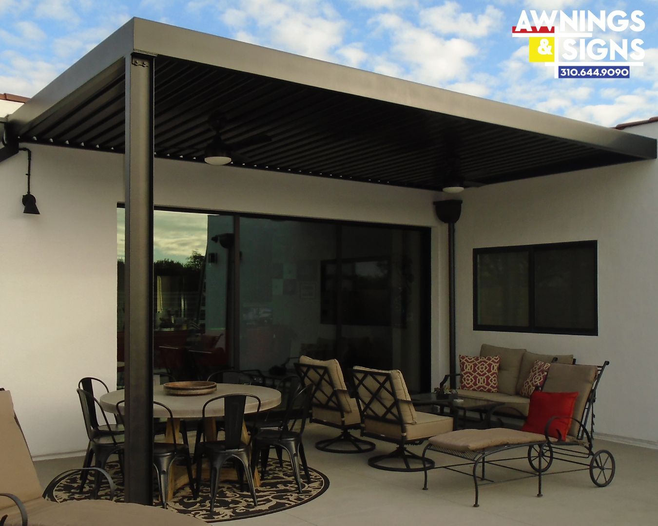 Black pergola over patio with outdoor furniture.