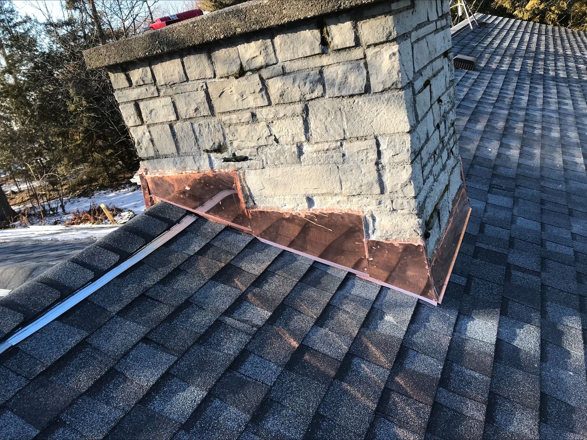 A brick chimney is sitting on top of a roof.