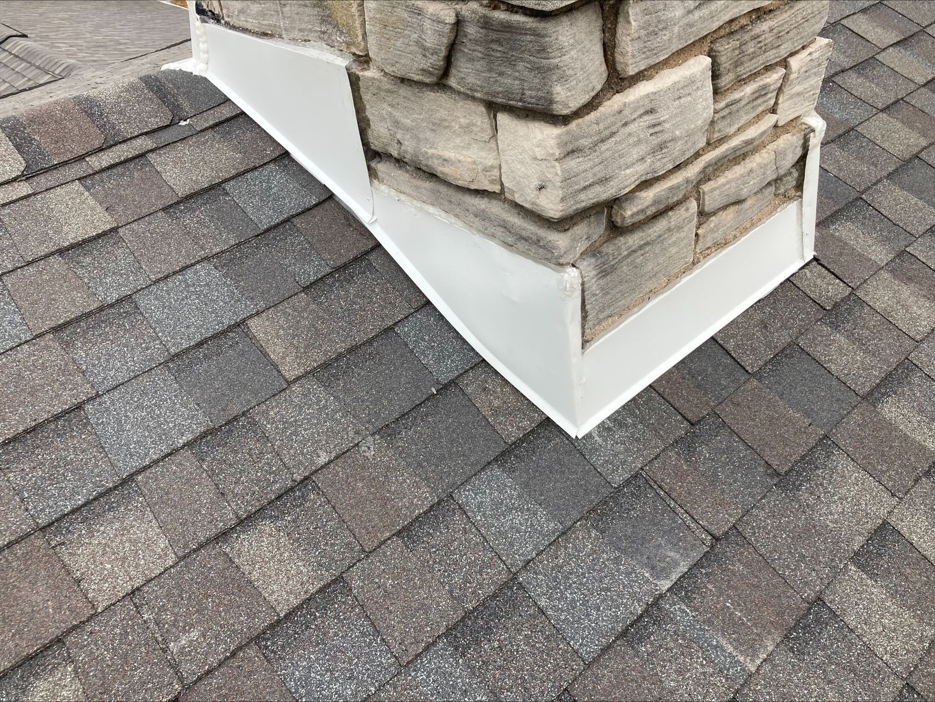 A chimney is sitting on top of a brick roof.