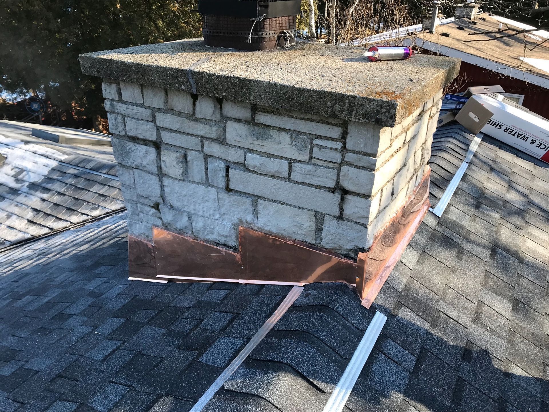 A brick chimney is sitting on top of a roof.