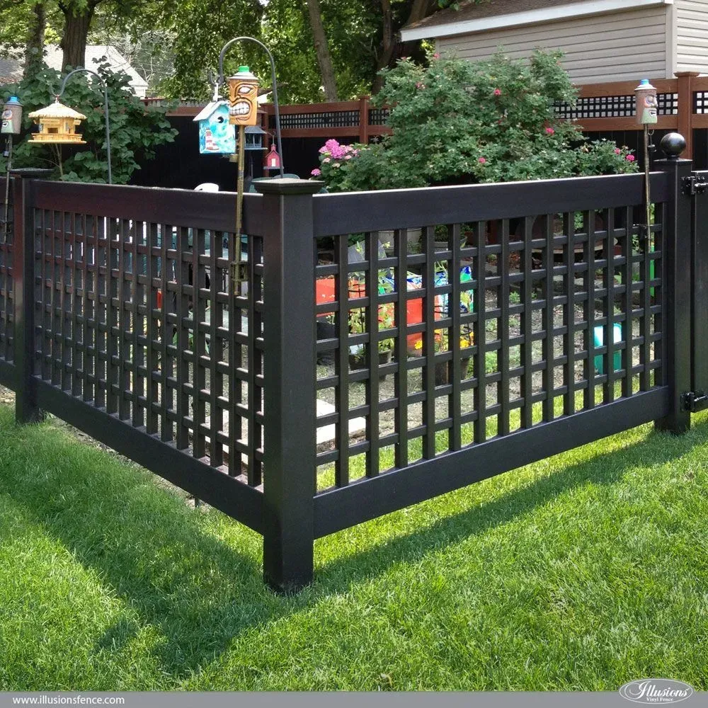 Black lattice fence in a yard with green grass and decorative birdhouses.