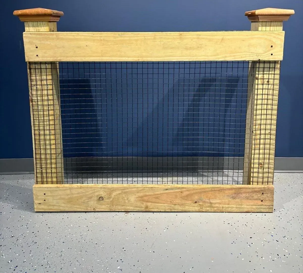 Wooden gate with metal mesh, decorative columns, and dark blue backdrop.