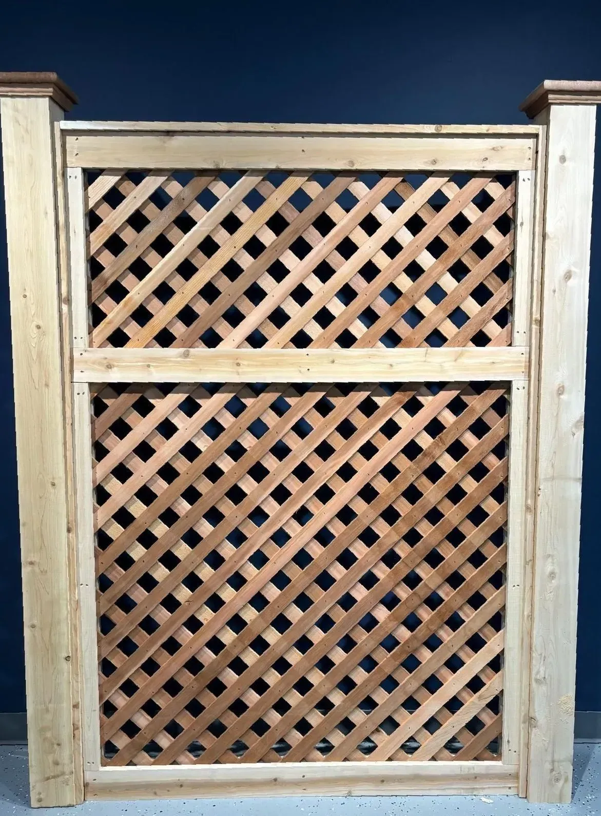 Wooden lattice fence section with a dark blue background.