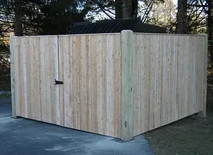 Wooden enclosure with a door, likely a trash bin or storage unit.