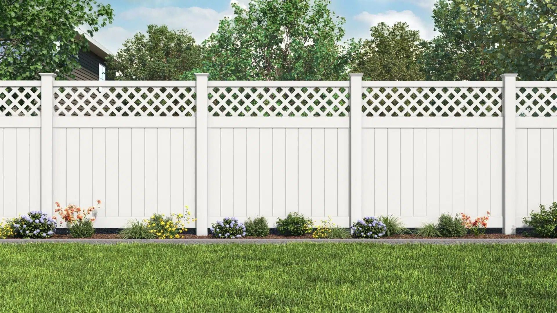 White picket fence with lattice top, lush green grass, colorful flowers, and trees in background.