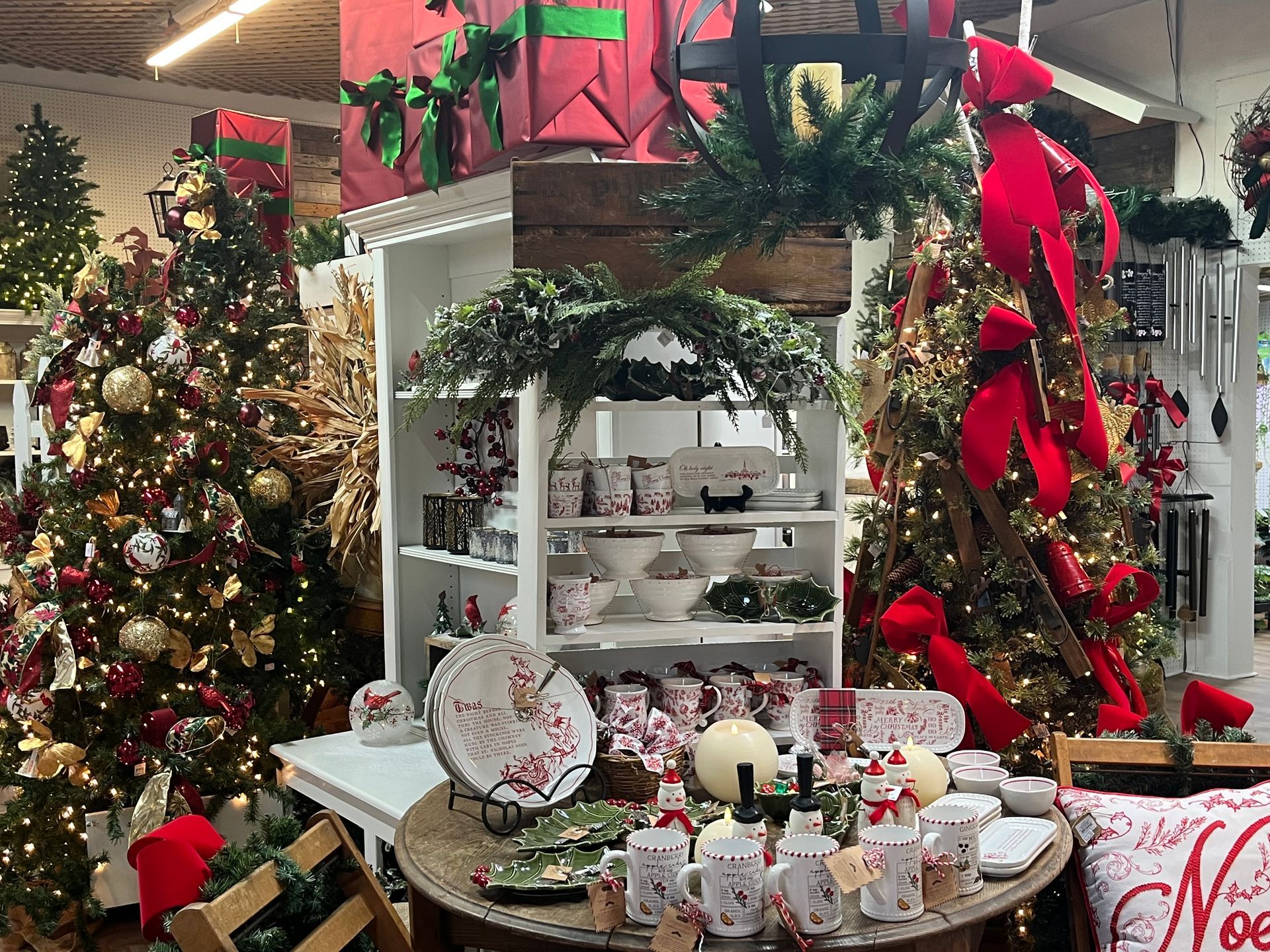 Christmas-themed store display with lit trees, gifts, and holiday merchandise.