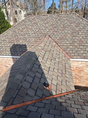 Brick house exterior with a chimney, pathway, and small shrubs.