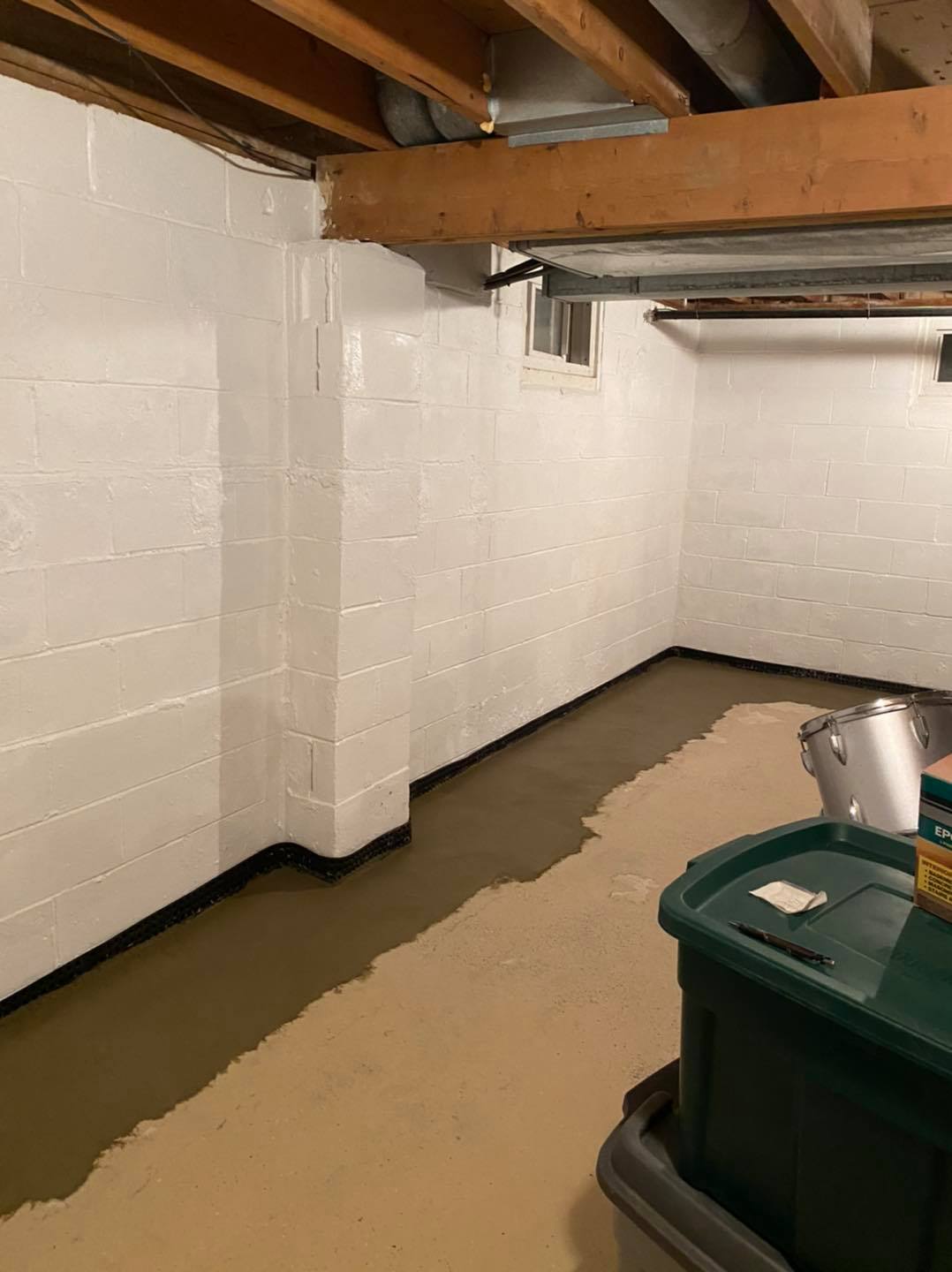 A basement with white brick walls and a concrete floor.