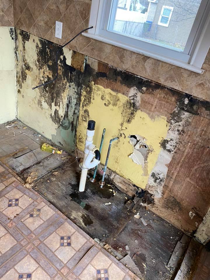 A kitchen with a sink and a window in it is being remodeled.