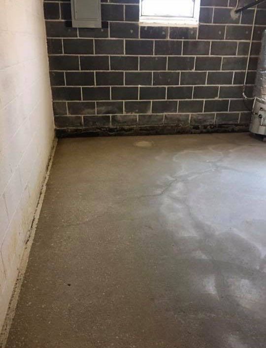 A room with a brick wall and a concrete floor.