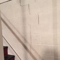 A brick wall with a staircase in the background.