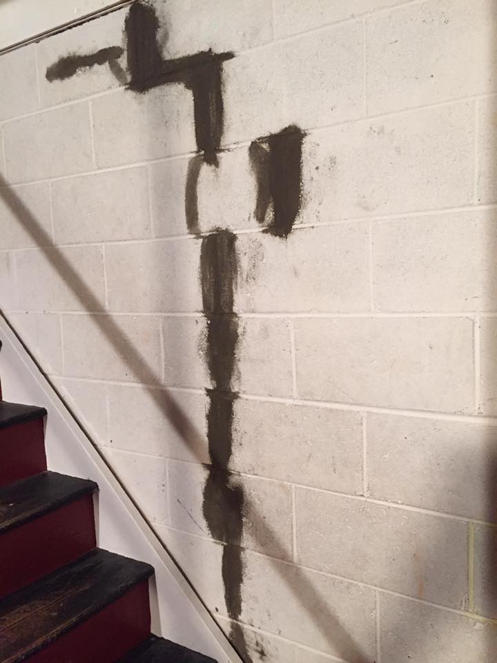 A brick wall with a staircase in the background.