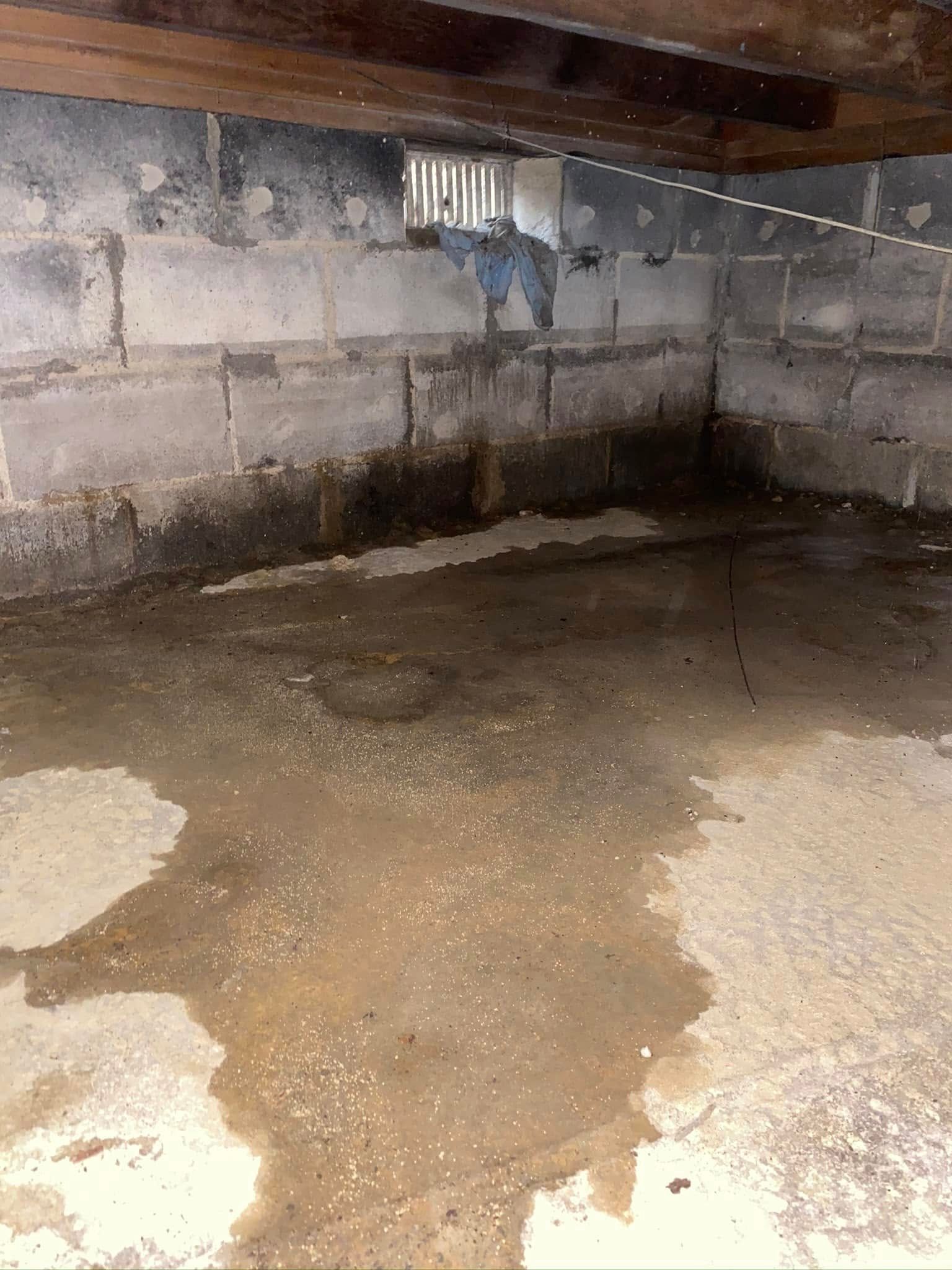 A dirty basement with a lot of water coming out of it.