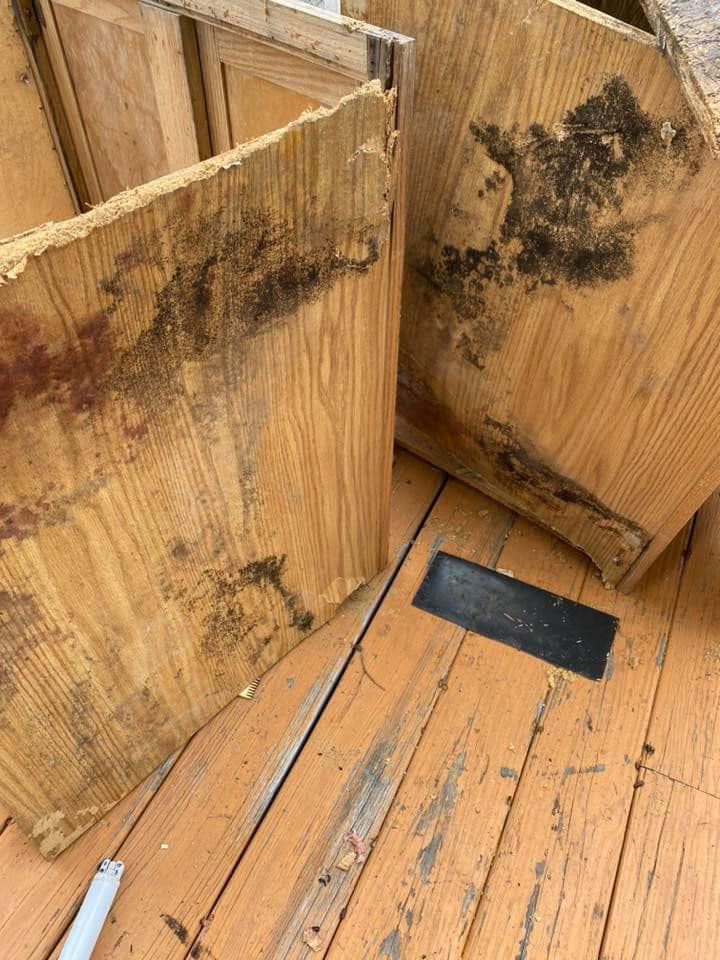 Two pieces of wood are sitting on a wooden floor.