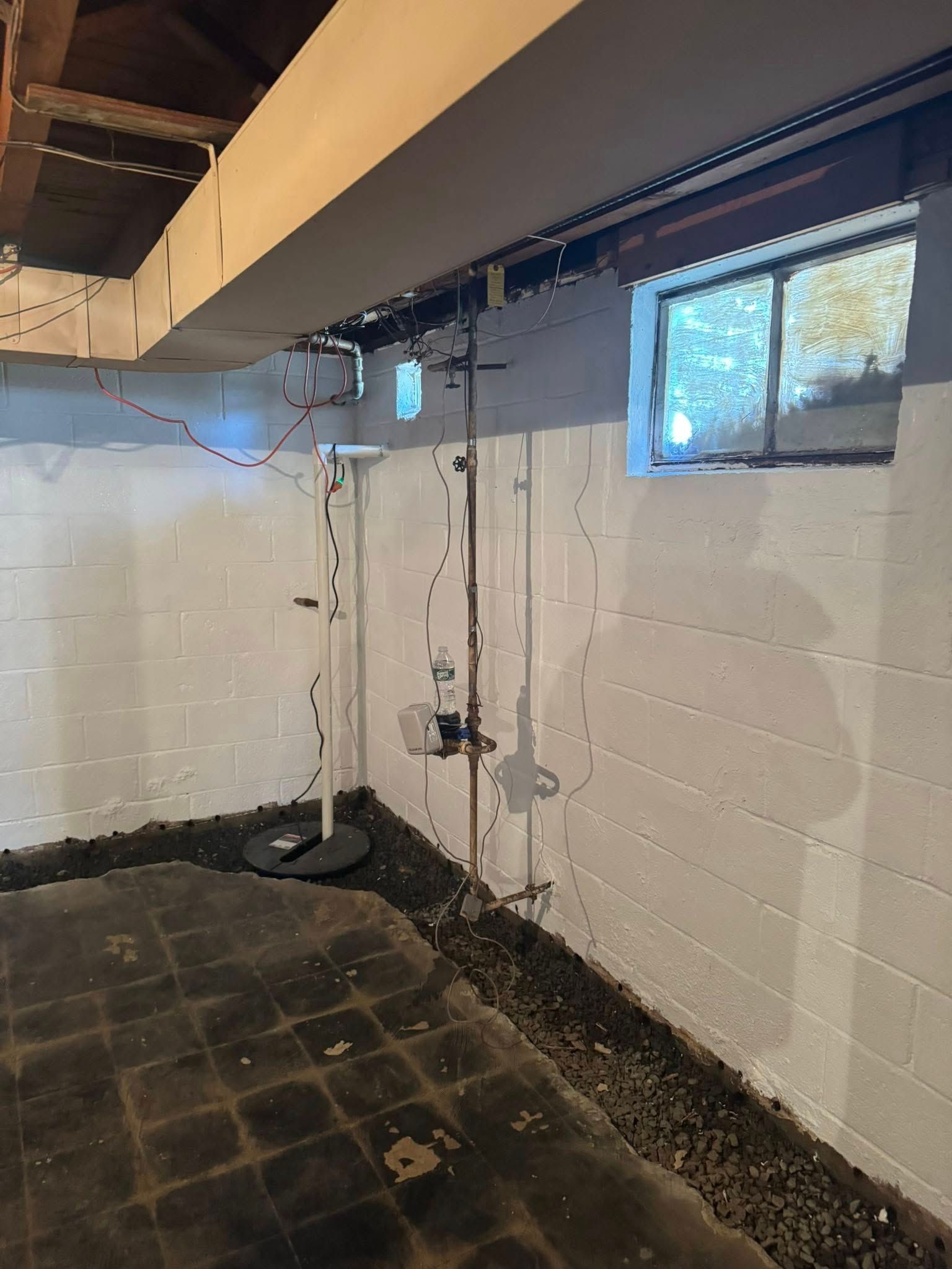 A basement with white brick walls and a window.