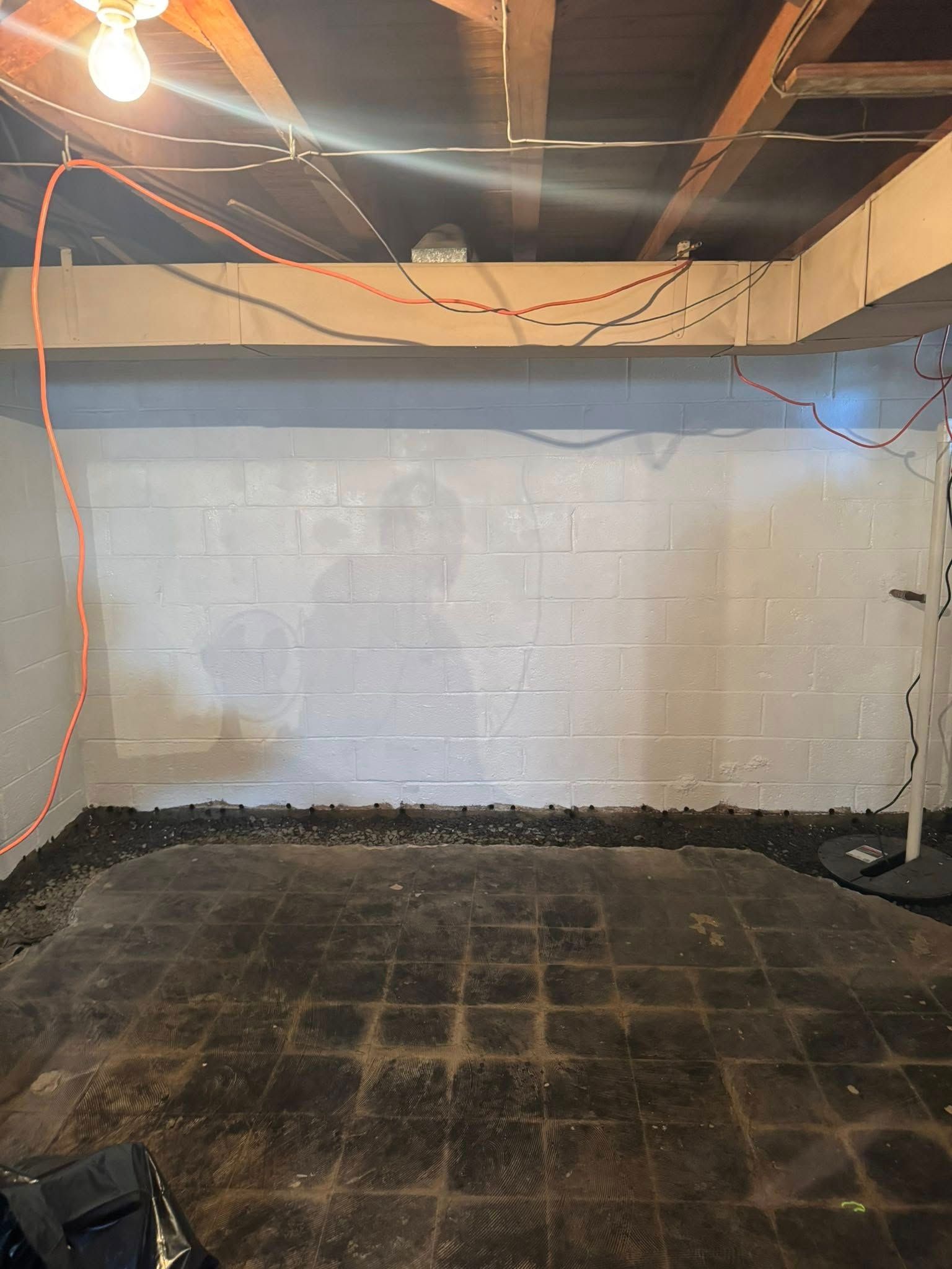 A basement with a brick wall and a tiled floor.