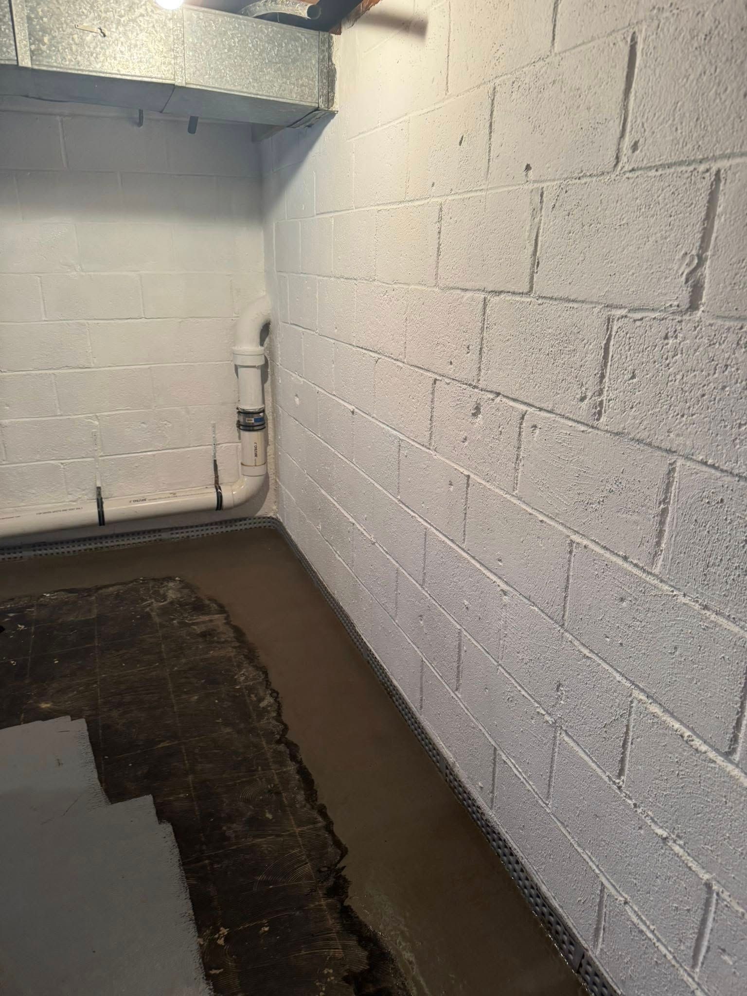 A basement with white brick walls and a concrete floor.