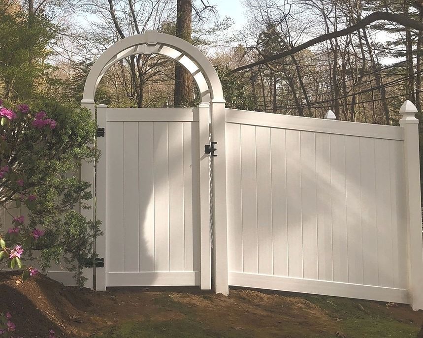 A white fence with a gate in the middle of it