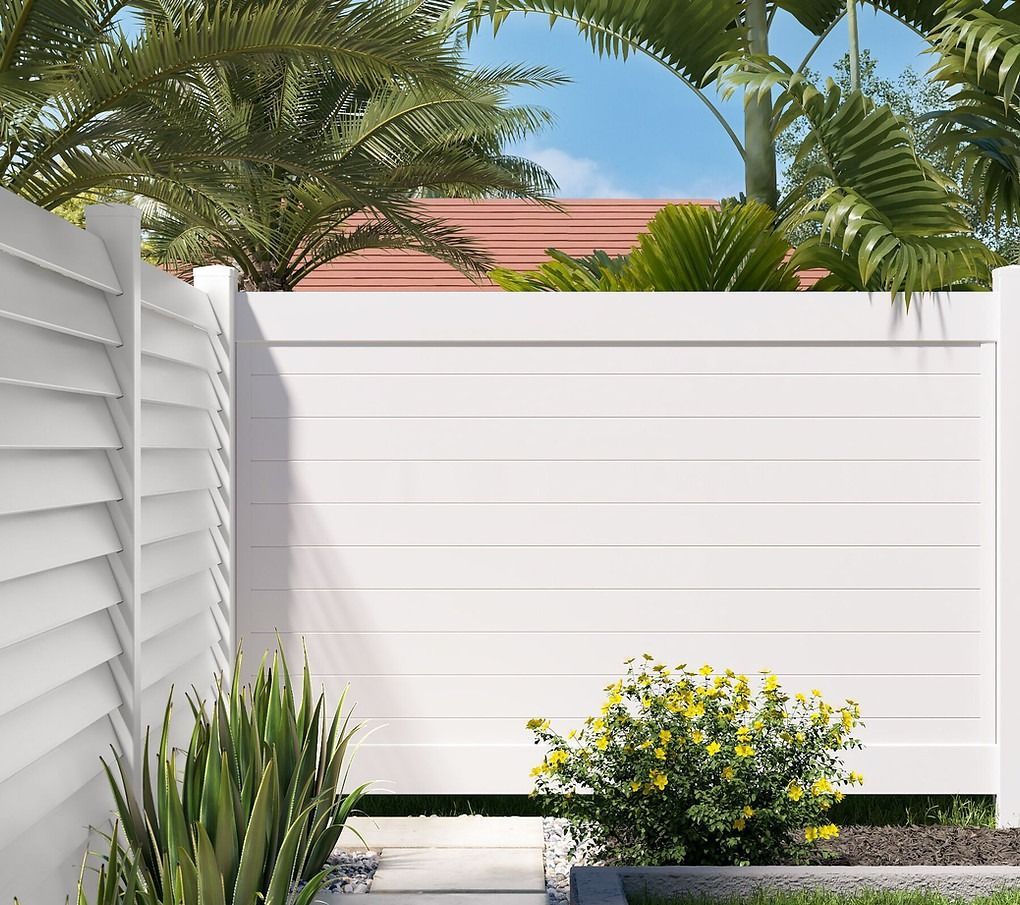 A white fence with palm trees in the background