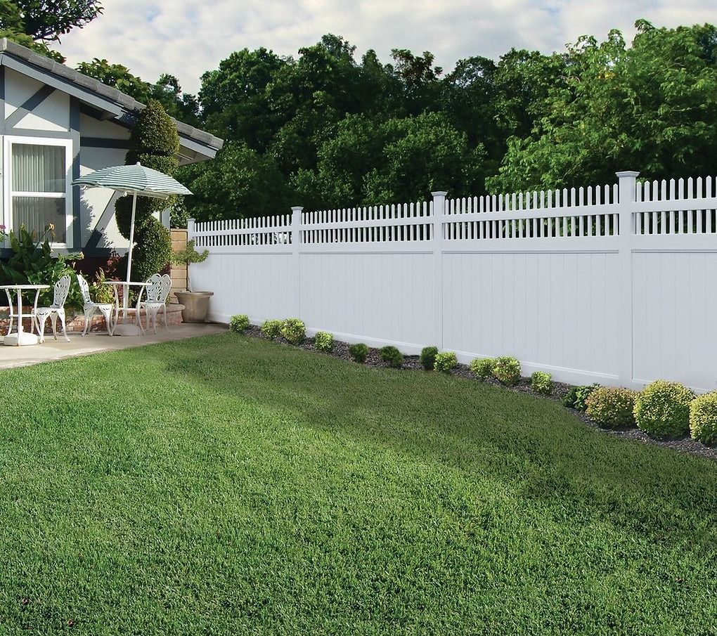A white fence surrounds a lush green yard