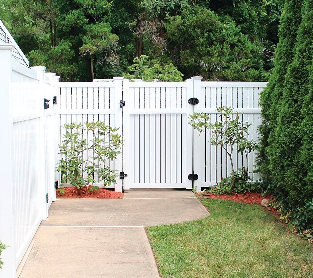 A white fence with a gate in the backyard