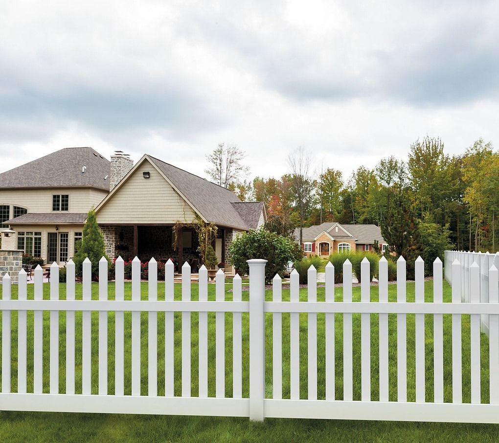 A white picket fence in front of a house