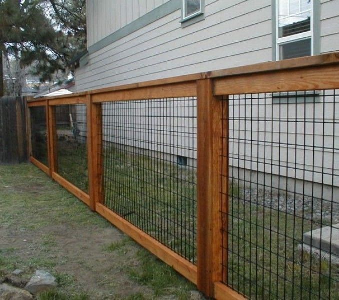 A wooden fence with a wire fence in front of a house
