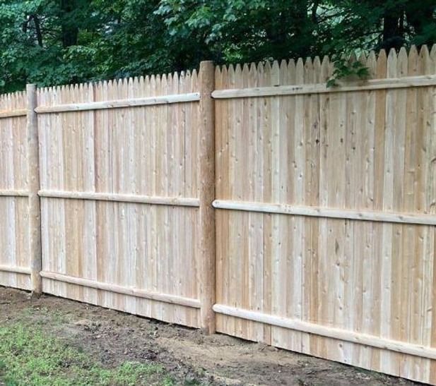 A wooden fence is sitting in the middle of a grassy field