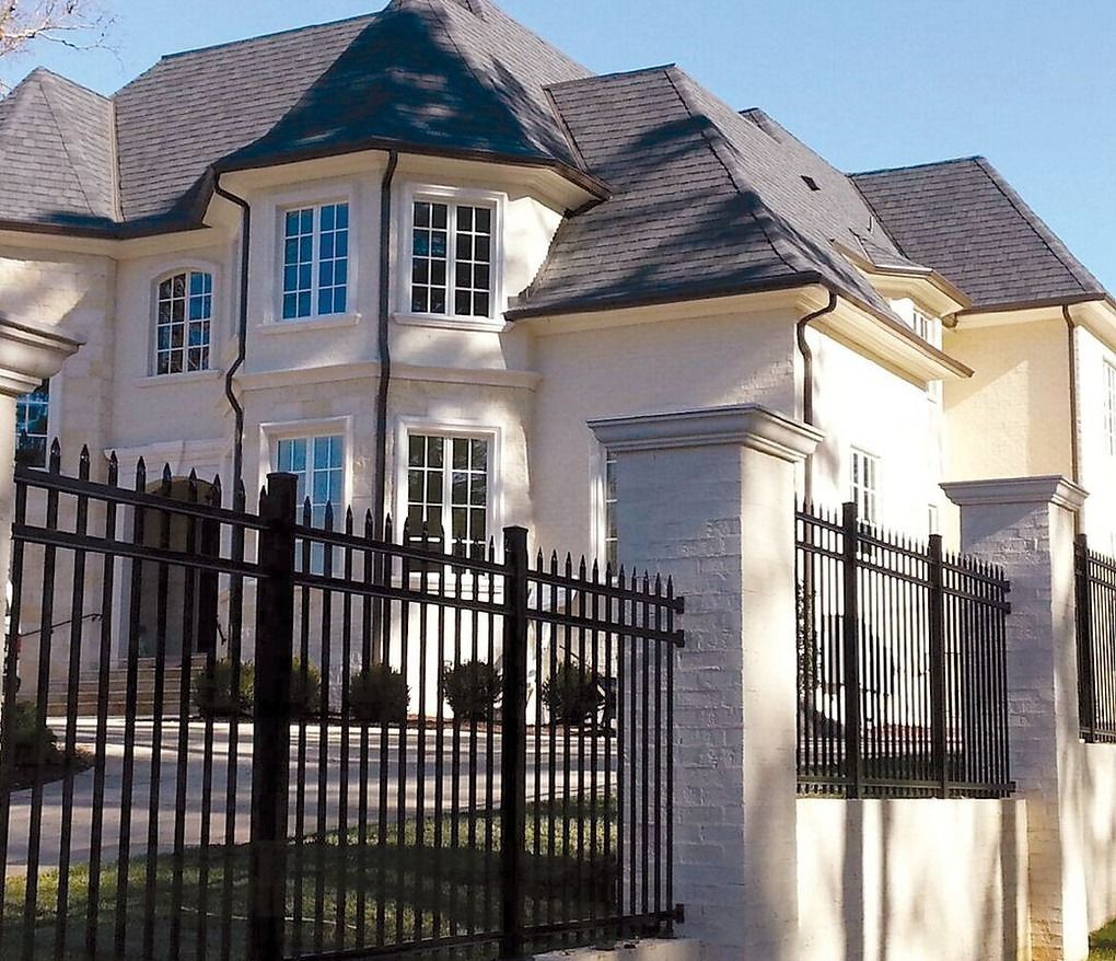 A large white house with a black fence around it