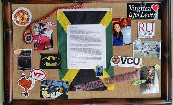 A corkboard with various photos, a Jamaican flag, and collegiate logos. Includes images of people and a